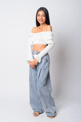 Full body shot of happy young beautiful Asian woman smiling