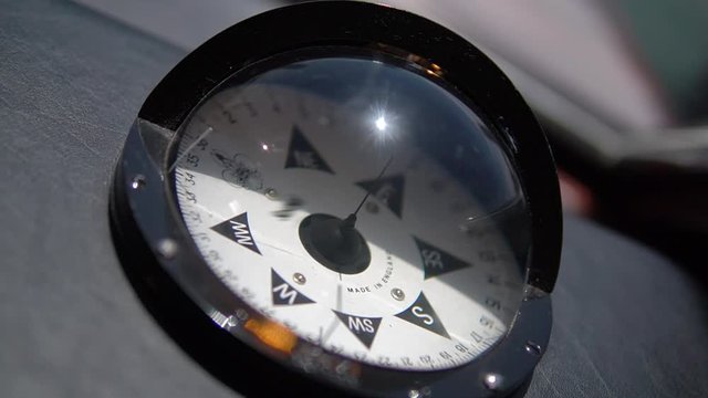 Close up and slow motion of compass in black case on ship, large marine compass