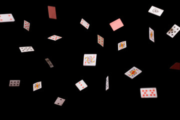 Game cards strew on a black background. Isolate. banner. Many playing cards of different suits on a black background. Close-up, opy space.    