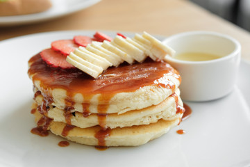 Delicious pancakes with strawberries, bananas and sauce. Cafe Breakfast Concept