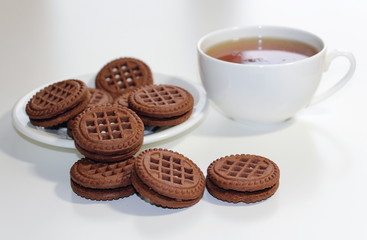 Cookies with chocolate. White cup with black tea. Tea ceremony. Sweet morning. Still life.
