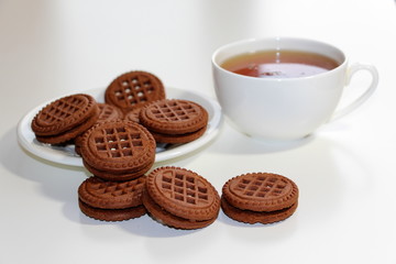 Cookies with chocolate. White cup with black tea. Tea ceremony. Sweet morning. Still life.