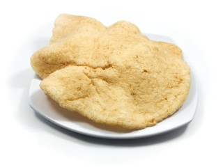Kerupuk udang or Fried shrimp crackers on a plate and white background