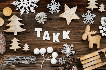 White Letters Building The Word Takk Means Thank You. Wooden Christmas Decoration Like Tree, Sled And Star. Brown Wooden Background
