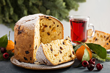 Traditional Christmas panettone with dried fruits and orange zest on light background