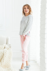 Naklejka premium Morning portrait of beautiful smiling woman in pajamas in light interior