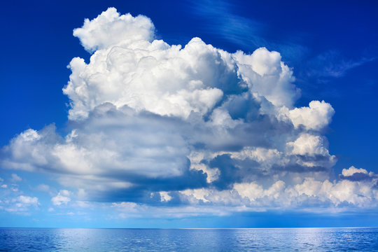 White cumulus clouds over sea close up blue sky background landscape, big fluffy cloud above ocean water panorama, scenic tropical sunny summer day cloudy weather seascape view, cloudscape, copy space © Vera NewSib