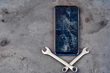Smartphone repair concept. Damaged display of smartphone and tools