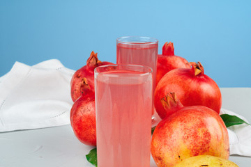 Glass of pomegranate juice and fruits on a table