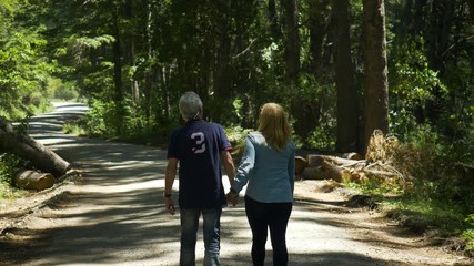 Senior couple walking in the woods - Powered by Adobe