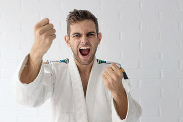 young martial arts athlete shouting with fists raised