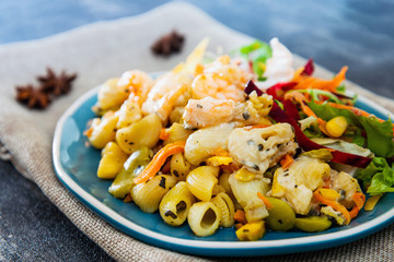 Cooked pasta with peeled shrimp, coconut milk sauce and broccoli