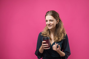 Glamor woman with a drink of coffee on a pink background	