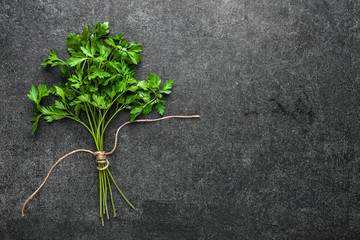 Fresh parsley, green herb on dark background