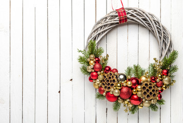 Golden and red composition of baubles on Christmas wreath on wooden background