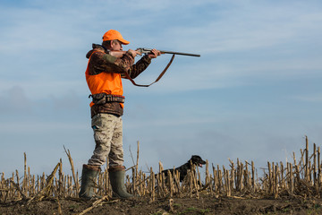 Hunting period, autumn season open. A hunter with a gun in his hands in hunting clothes in the...