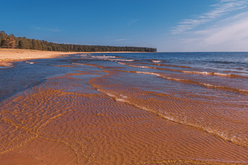 The shore of Lake Ladoga. Coastline and waves near the beach. Summer landscape.