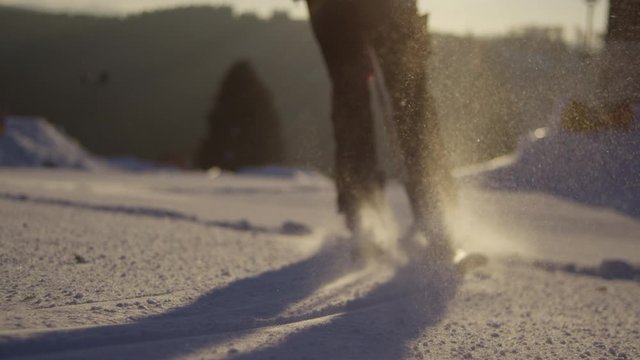 Skifahrerinn fr&uuml;h morgens auf der Piste, close up von schnee verwirbellungen 