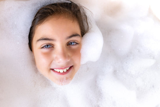 Beautiful girl taking a relaxing foam bath