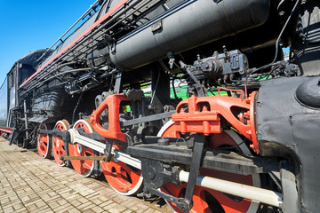 Fragment of the chassis of the old engine, wheels, springs, axle boxes, pistons and cylinders