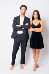 Full body shot of multi ethnic business couple together with arms crossed