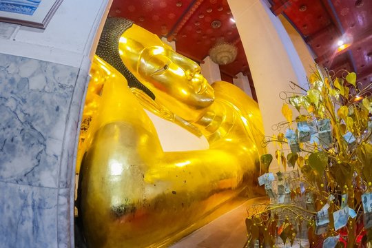 Big gold buddha statue at Wat Phra Non Chaksi, Singburi, Thailand. Beautiful of historic city at buddhism temple.