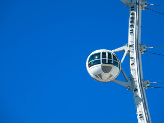 Detail of Ferris wheel on blue sky background