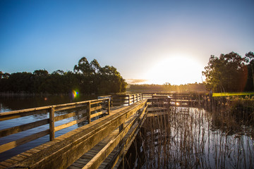 Holzbrücke auf einem See beim Sonnenaufgang