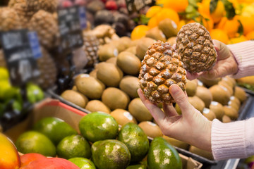 Female hand choosing pine cone in the store. Concept of healthy food, bio, vegetarian, diet.