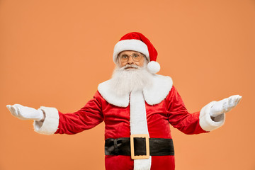 Fototapeta na wymiar Authentic Santa Claus standing in studio with open palms