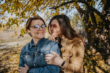 Fototapeta premium LGBT women. Young lesbian couple walking in the park together. Delicate relationship. Selective focus