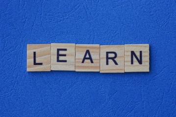 word learn from wooden letters lie on a blue table