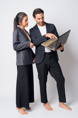 Full body shot of multi ethnic business couple using laptop together