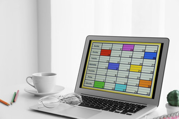 Modern laptop with calendar on screen in office
