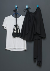 uniform for classical dance and ballet hanging on a gray background.