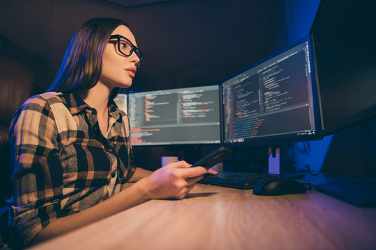 Low below angle view photo of concentrated focused woman in glasses comparing database in her computers and phone trying to find errors to solve