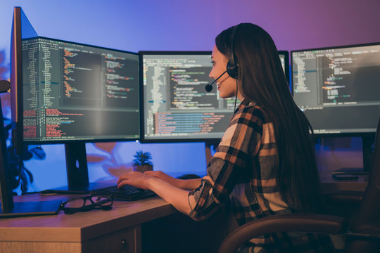 Photo of hard-working programmer consulting her colleagues at late night waiting shift to end sitting before screens
