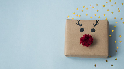 New year Christmas DIY gift in the form of a christmas deer on a blue background with gold stars. Copy space.