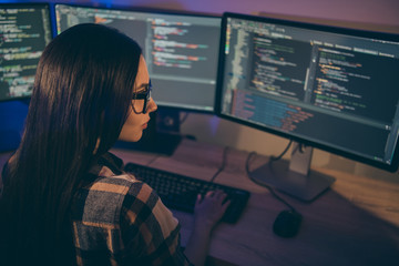 Photo of serious confident focused girl concentrated on hacking the security code of her opponents in spectacles using java script