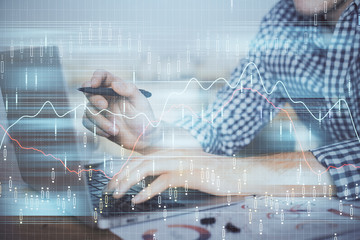 Double exposure of forex graph with man working on computer on background. Concept of market analysis.