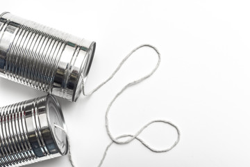 Communications and business calls concept of tin can telephone with string on orange