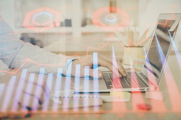 Multi exposure of stock market graph with man working on laptop on background. Concept of financial analysis.