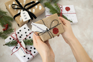 Female hands hold a stylish handmade Christmas New Year present.