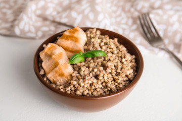 Tasty buckwheat porridge with meat on white table
