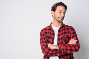 Portrait of Hispanic hipster man looking down with arms crossed