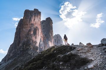 young girl in front of the beautiful three peaks of lavaredo mountains on a sunny day enjoying the view. northern Italy landscape in the tre cime di lavaredo national park