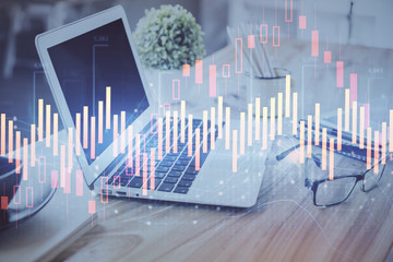 Stock market graph on background with desk and personal computer. Double exposure. Concept of financial analysis.