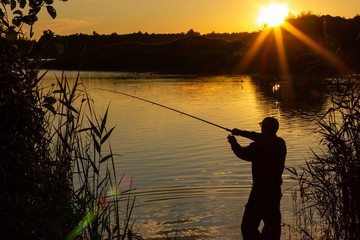 angler silhouette during summer sunset with lens flare