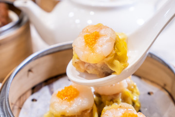 Siu Mai, one of Dim Sum yum cha, pork and shrimp steamed dumplings on restaurant house white background table for breakfast, lifestyle, close up.