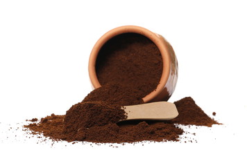Instant espresso powdered coffee in clay pot with small wooden spoon, isolated on white background